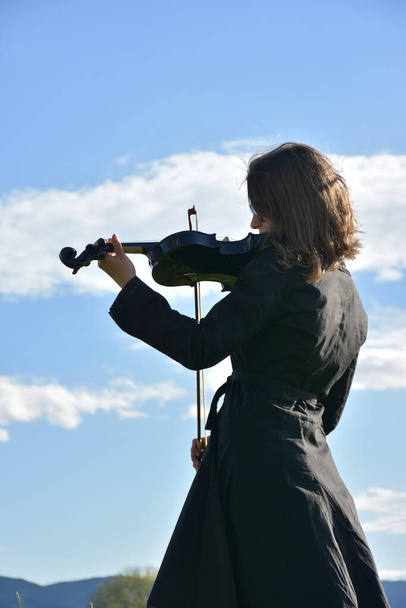 a girl in a black dress with a black violin, - Photo, Image