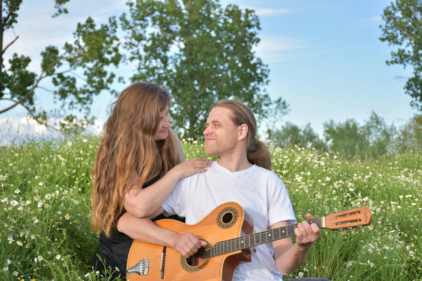 μια γυναίκα και έναν άντρα με μια κιθάρα, - Φωτογραφία, εικόνα