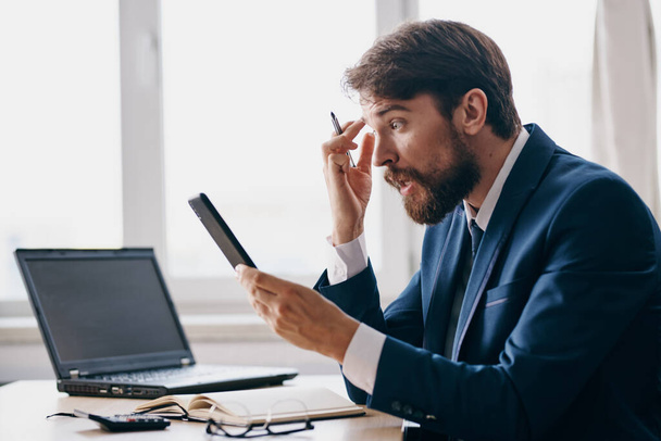 hombre barbudo sentado en un escritorio frente a un ordenador portátil, el estrés y la ira. Foto de alta calidad - Foto, imagen