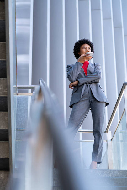 A young African-American businesswoman talking on the phone in a business building - Photo, Image