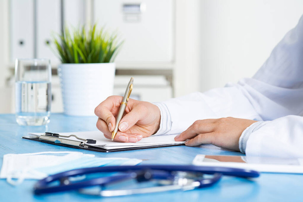 Close-up of female doctor filling medical form - Photo, Image
