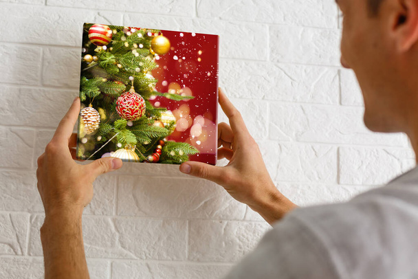 чоловік тримає фотографічне полотно з зображенням Різдва
 - Фото, зображення