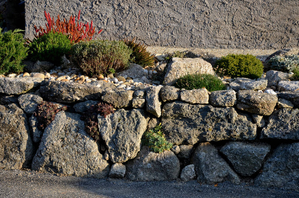 kuiva harmaa seinä, taitettu lohkareita ilman sementtiä. taitetut tukimuurit. erittäin värikäs rock puutarhat kuten kivinen ympäristö. puutarha arkkitehtuuri - Valokuva, kuva