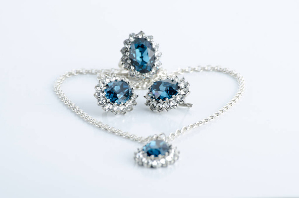 Ongebruikelijke luxe mooie sieraden, oorbellen gemaakt van echte planten bedekt met zilver, met reflectie op een witte achtergrond. - Foto, afbeelding
