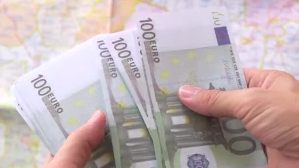 Mies, jolla on hallussaan euromääräistä paperia ja joka laskee 100 euroseteliä - Materiaali, video