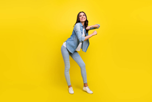 Photo of adorable funny young lady wear jeans shirt smiling dancing isolated yellow color background - Valokuva, kuva