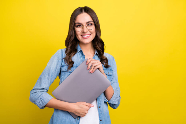 Photo of shiny pretty woman dressed denim shirt glasses holding modern gadget empty space isolated yellow color background - Φωτογραφία, εικόνα