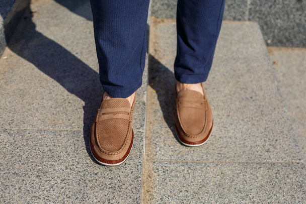 Male brown shoes made of genuine leather close-up on male feet - 写真・画像