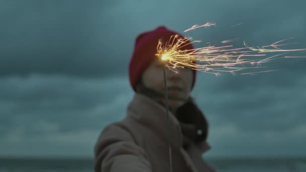 Vrouw met fonkelende stok op het strand - Video