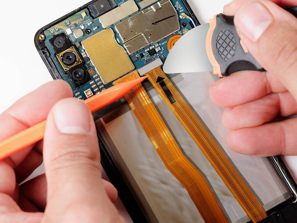 Close up hands of technician repairing smartphone do it yourself concept of computer hardware, mobile phone, electronic, repairing, upgrade and technology fixing - Фото, изображение