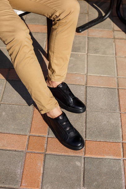 Men's sneakers or shoes made of genuine leather on men's legs close-up. - 写真・画像
