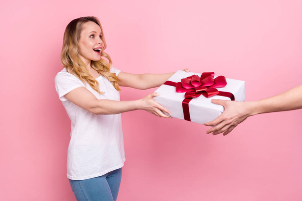 Photo of amazed cheerful young happy woman give hands present surprise isolated on pink color background - Foto, Bild