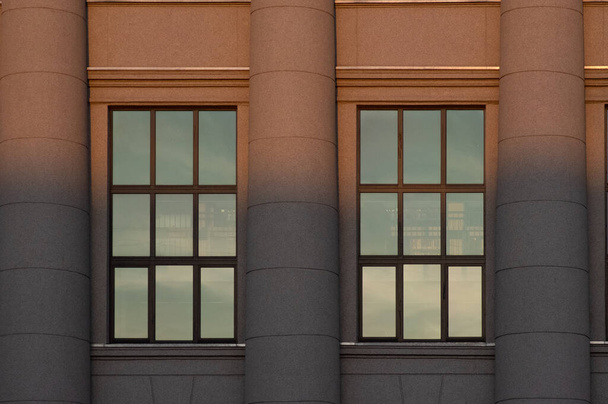 A könyvtár ablaka három oszlopból áll, a naplementével kettéosztva. - Fotó, kép