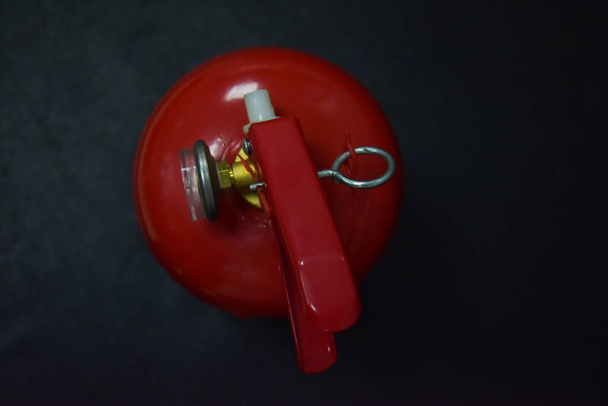 Sur fond noir, un gros plan d'un manomètre sur un extincteur rouge montre la pression dans le cylindre. Un dispositif spécial pour éteindre un incendie. Prenez l'extincteur.! - Photo, image