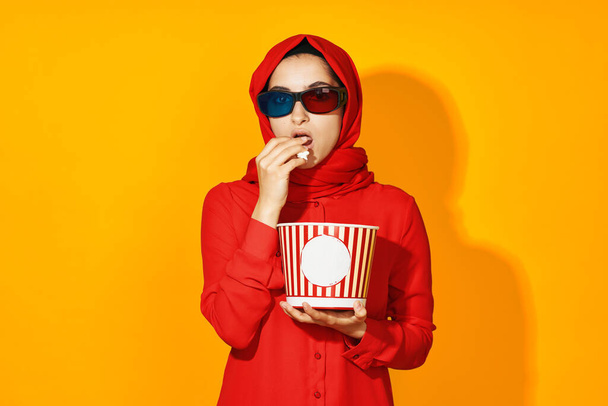 mujer árabe palomitas de maíz entretenimiento cine amarillo fondo - Foto, Imagen