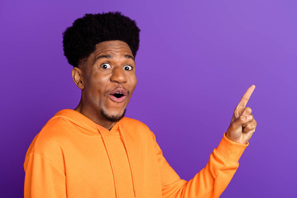 Photo of attractive young afro american man point finger empty space shock sale isolated on purple color background - Foto, Imagen
