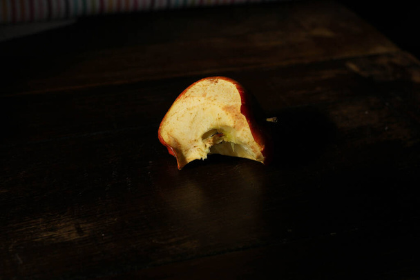 bitten apple, stub on a dark wooden background  - Fotó, kép