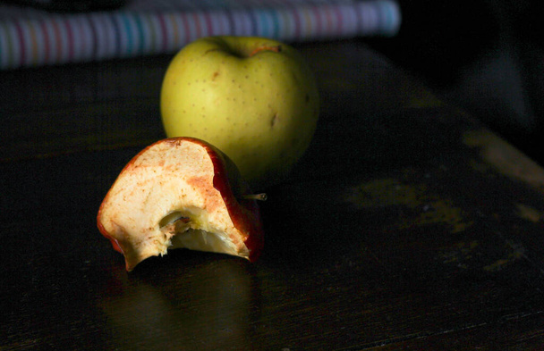 bitten apple, stub on a dark wooden background  - Photo, Image