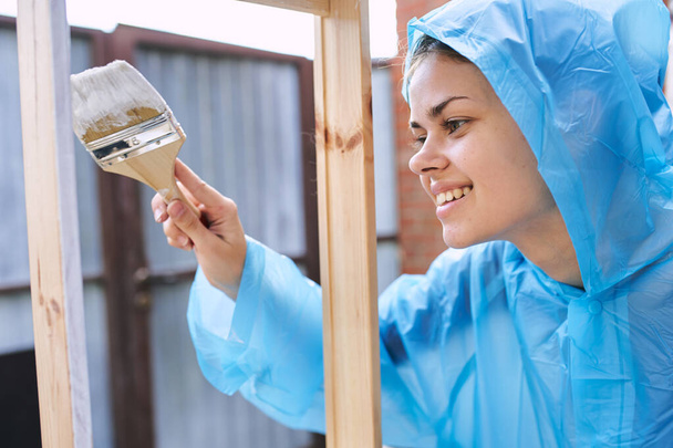 woman in protective suit painting wood renovation design - Valokuva, kuva