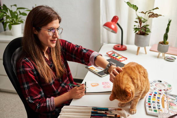 Kadın tele-iş yaparken kedisini okşar - Fotoğraf, Görsel