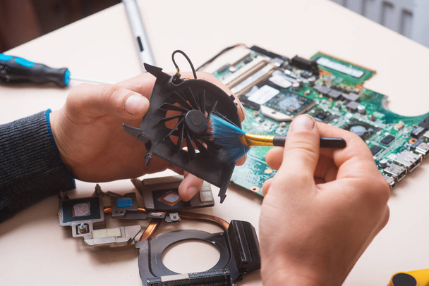 Assistent repariert Laptop mit Werkzeug und Händen - Foto, Bild