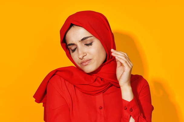 woman in red hijab attractive eyes fun gesture hands yellow background - Fotografie, Obrázek