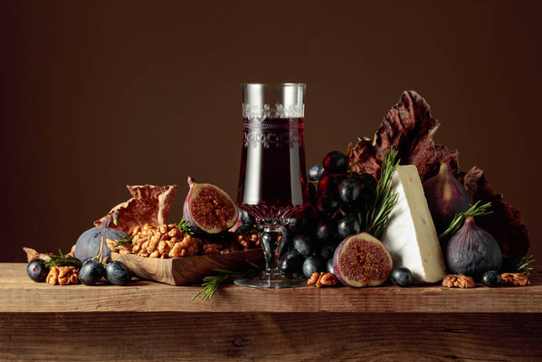 Červené dezertní víno se sýrovým brie a ovocem na dřevěném stole. Kopírovat prostor. - Fotografie, Obrázek