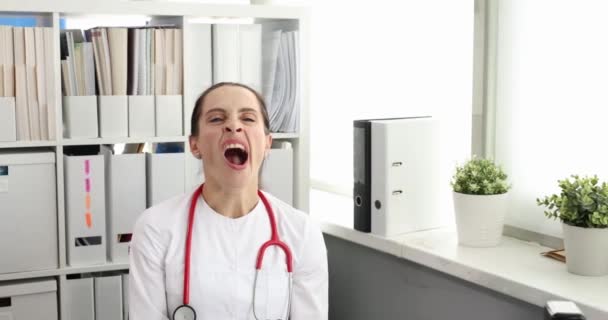 Νεαρή γυναίκα γιατρός χασμουρητό στο γραφείο 4k ταινία αργή κίνηση - Πλάνα, βίντεο