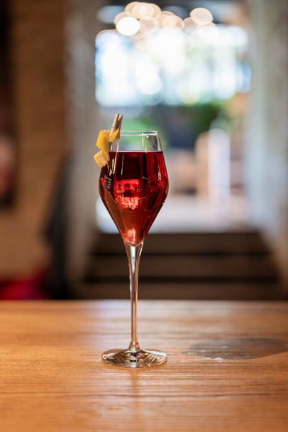deliciosa bebida cóctel alcohólico en un vaso de cristal rojo en un mostrador de bar - Foto, imagen