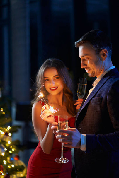 Couple celebrating new year with sparklers and champagne - Zdjęcie, obraz