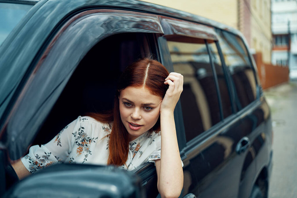 cheerful woman driving a car looks out of the window - Foto, Imagem