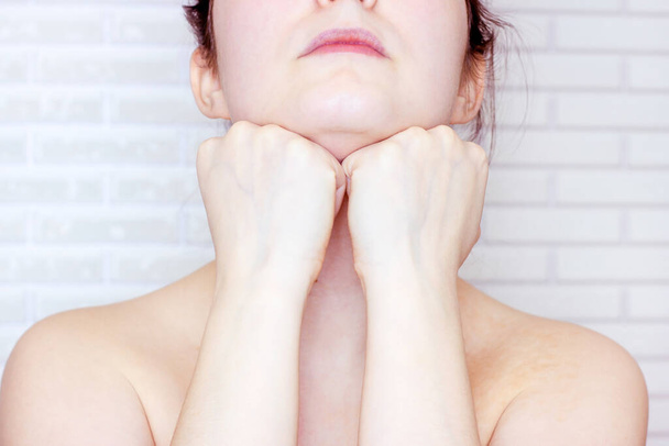 Young caucasian woman touching her face with hands doing face fitness exercises. Facial lifting and massage concept. - Photo, Image