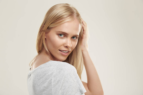 Portrait of young confident european girl. Beautiful blonde female teenager with blue eyes wear white t-shirt and looking at camera. Isolated on white background. Studio shoot - Foto, immagini