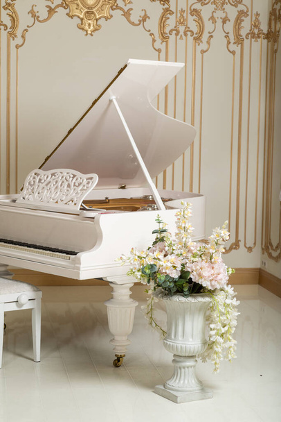 White piano and flowers in the interior. - Zdjęcie, obraz