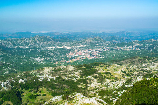 Top view to Cetinje city from viewpoint at top of Jezerski mountain, near Njegos mausoleum. Lovcen National Park. Montenegro. Summer blue top mountain landscape. - Photo, Image