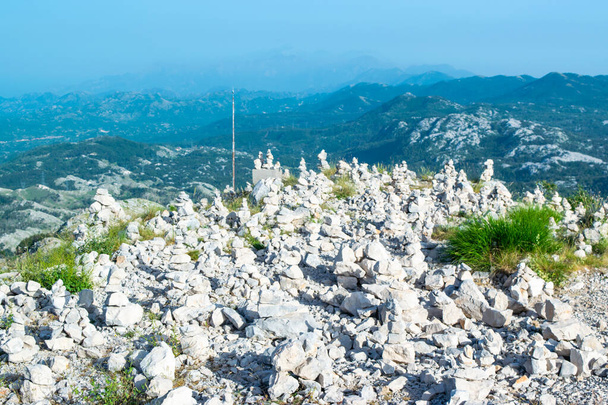 Torretas de pedra feitas por turistas para boa sorte no topo da montanha Jezerski perto de Njegos mausoléu. Parque Nacional Lovcen. Montenegro. Verão azul topo montanha paisagem. - Foto, Imagem
