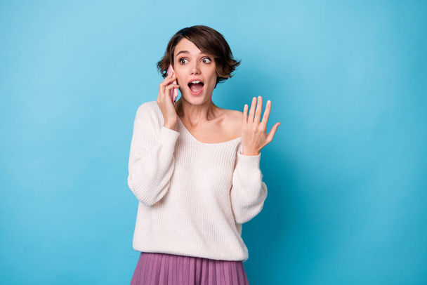 Photo portrait of surprised girl talking on phone isolated on pastel blue colored background - Φωτογραφία, εικόνα