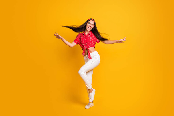 Full length photo of sweet cute young lady wear red shirt dancing hands arms sides isolated yellow color background - Fotó, kép