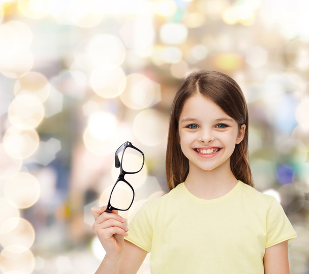 sorrindo bonito menina segurando óculos pretos
 - Foto, Imagem