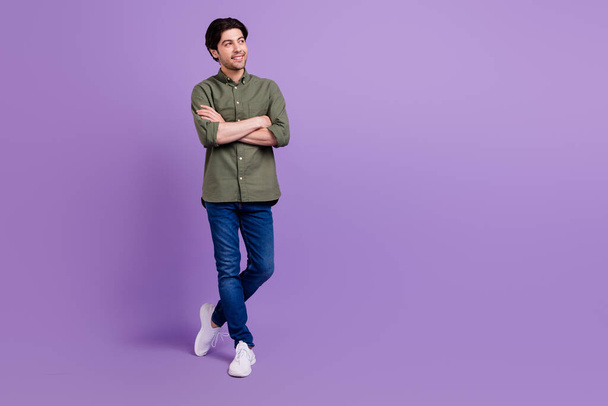 Full size photo of dreamy happy young man hold hands crossed look copyspace isolated on violet color background - 写真・画像