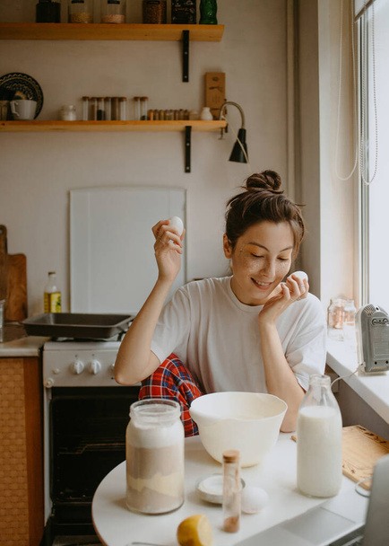 vrouw koken in pyjama in de keuken door de ochtend - Foto, afbeelding