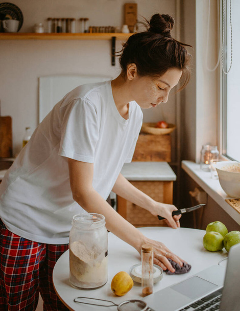 donna che cucina in pigiama in cucina al mattino - Foto, immagini