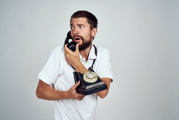 emotional bearded man talking on the phone light background - Φωτογραφία, εικόνα