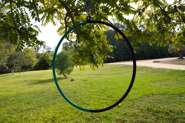 Arco aéreo pendurado em uma árvore em um parque para realizar exercícios ao ar livre. Ginástica e conceito de saúde - Foto, Imagem
