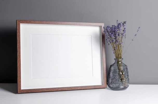 Landschap houten frame mockup voor kunstwerk, foto en print presentatie met droge laverder bloemen in vaas. Minimalistisch interieur. - Foto, afbeelding