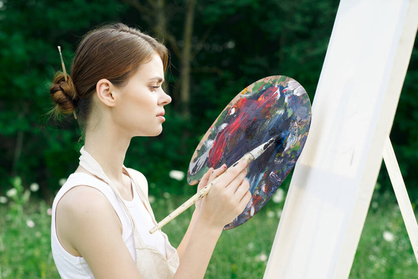woman artist paints palette easel nature drawing - Zdjęcie, obraz