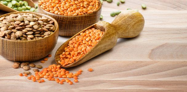 Lentils in a wooden bowls and scoop on wooden table - Photo, Image