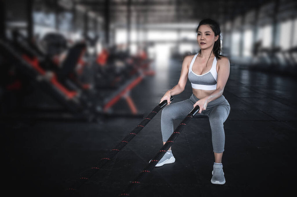 Asian strong woman exercise with battle ropes - 写真・画像