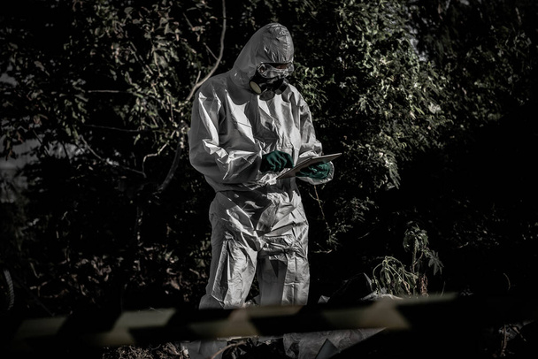 Asian scientist wearing Chemical protection suit working at dangerous zone collecting samples in case of Corona virus investigation outbreak from China. - 写真・画像