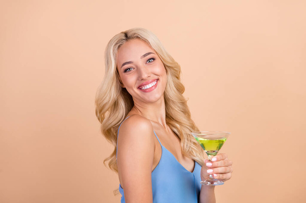 Profile side photo of young cheerful woman happy positive smile drink cocktail glass isolated over beige color background - Fotoğraf, Görsel